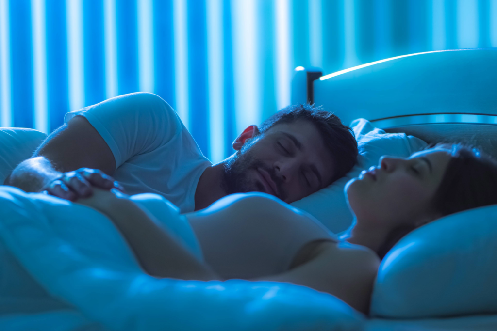 Casal dormindo em quarto escuro, simbolizando o impacto positivo do sono no emagrecimento.